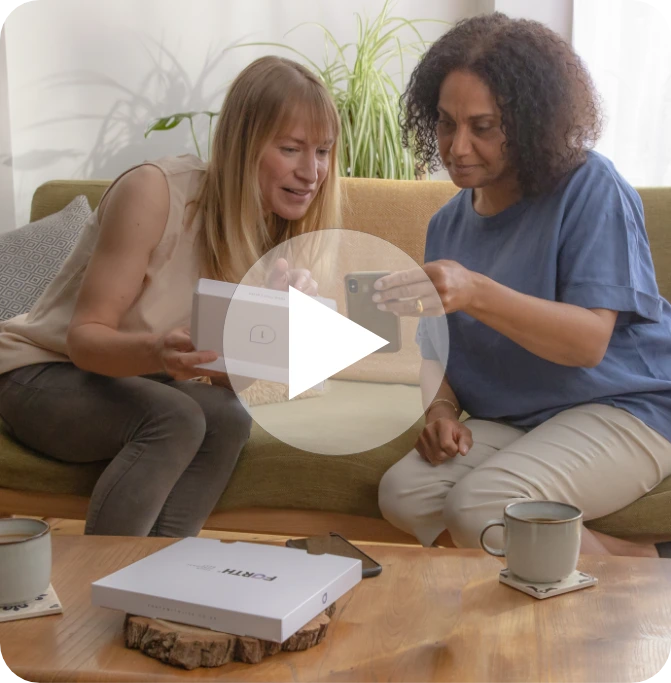 Two women looking at a phone with a MyFORM Kit